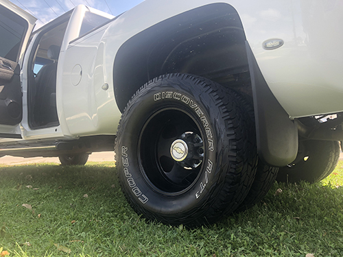 White truck with cleaned tires and rims from an exterior detail.